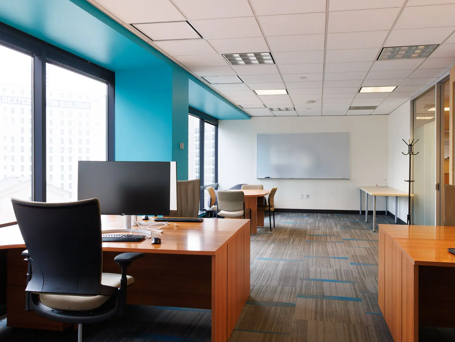 Long room with lots of light, whiteboard, and coat hanger.